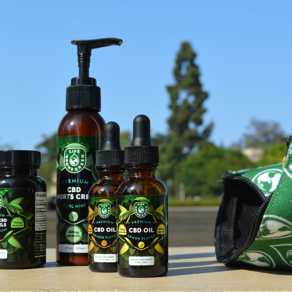 CBD oil and sports cream next to Life Grows Green pouch.
