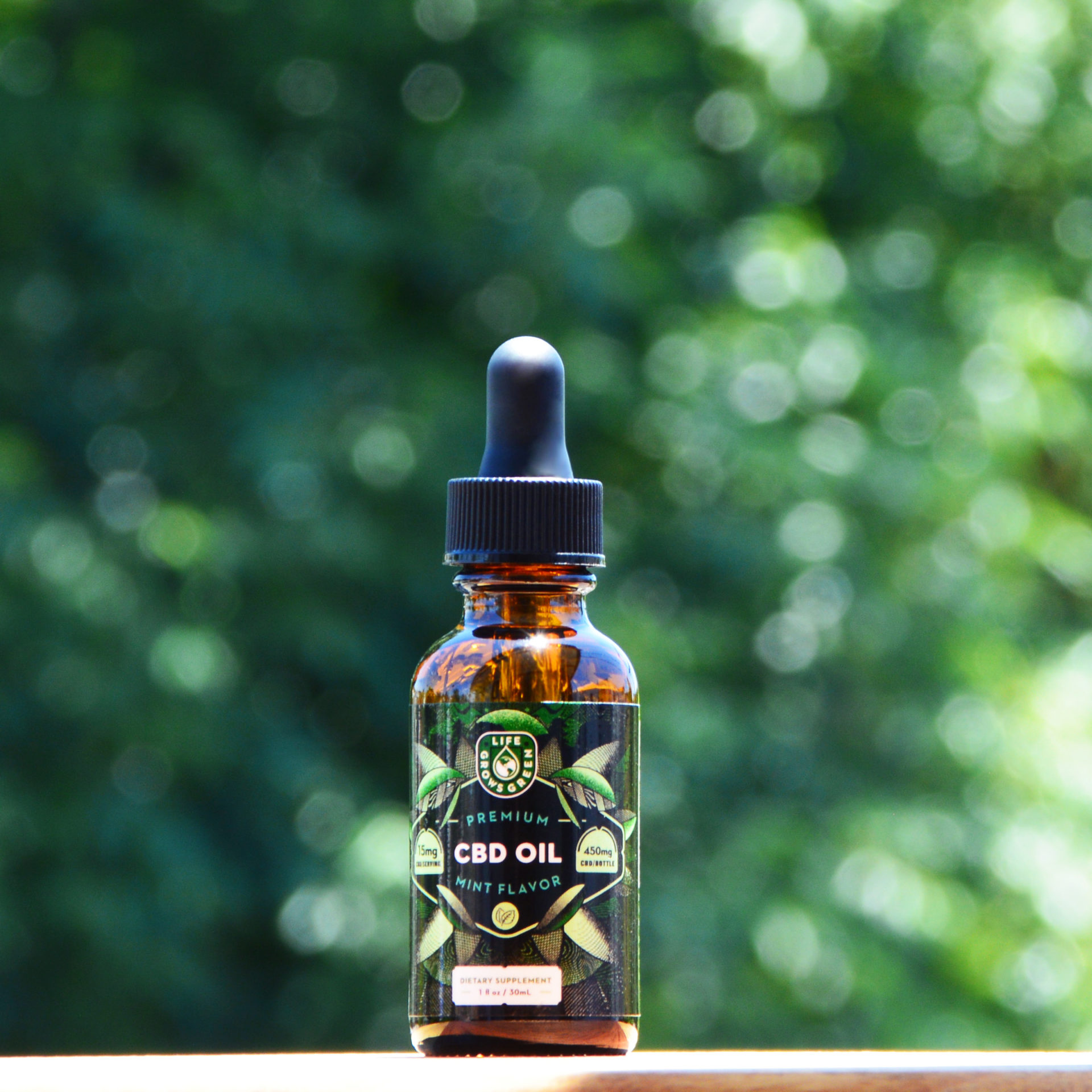 A bottle of mint flavored Life Grows Green CBD oil.