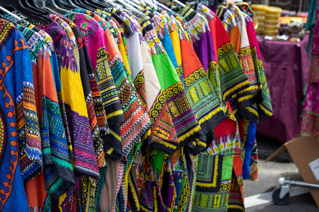 African Dashiki on clothing rack at outdoor market.