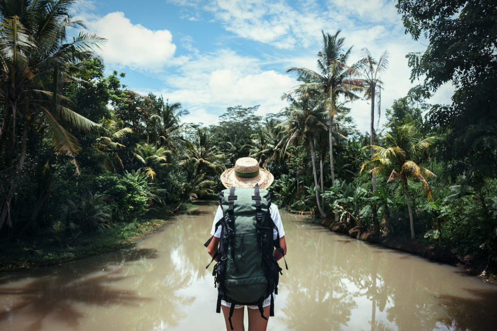 Woman with backpack in the jungle.