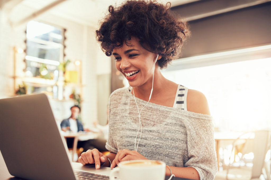 Young woman working in cafe with laptop.