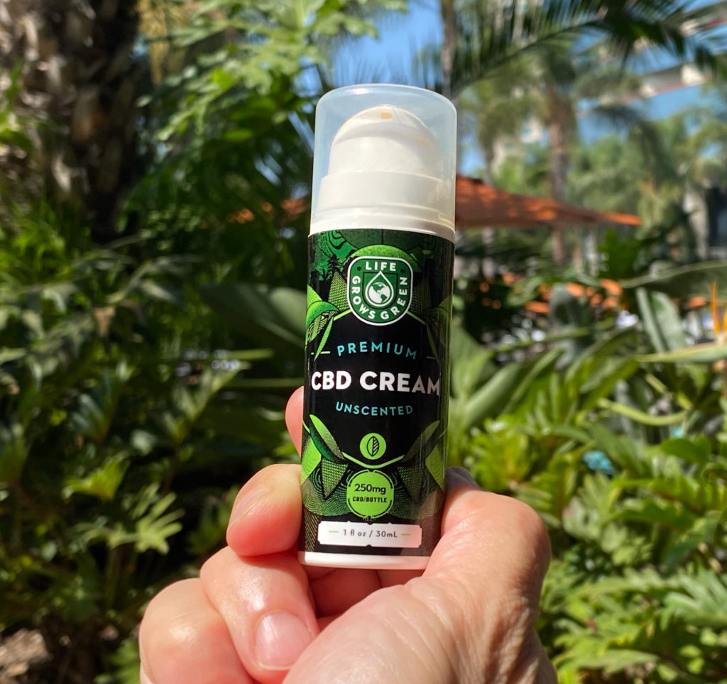 A man holding CBD cream from Life Grows Green. 