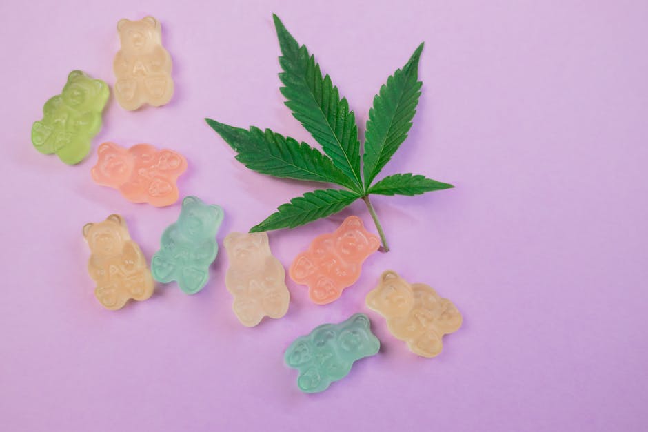 CBD gummies next to a cannabis leaf.