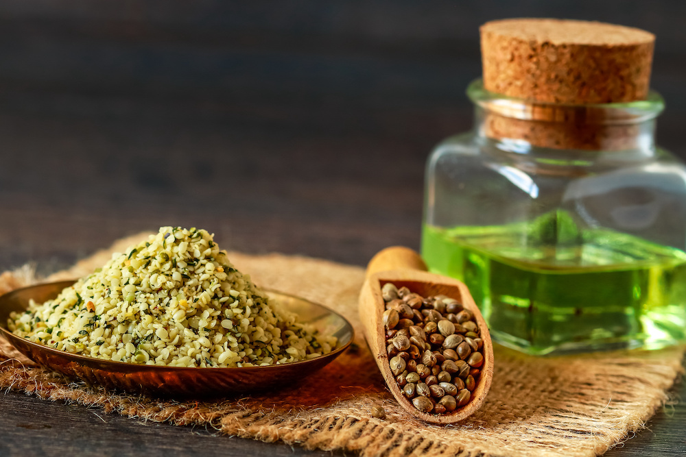 A plate of hemp seeds and a bottle of hemp oil. 