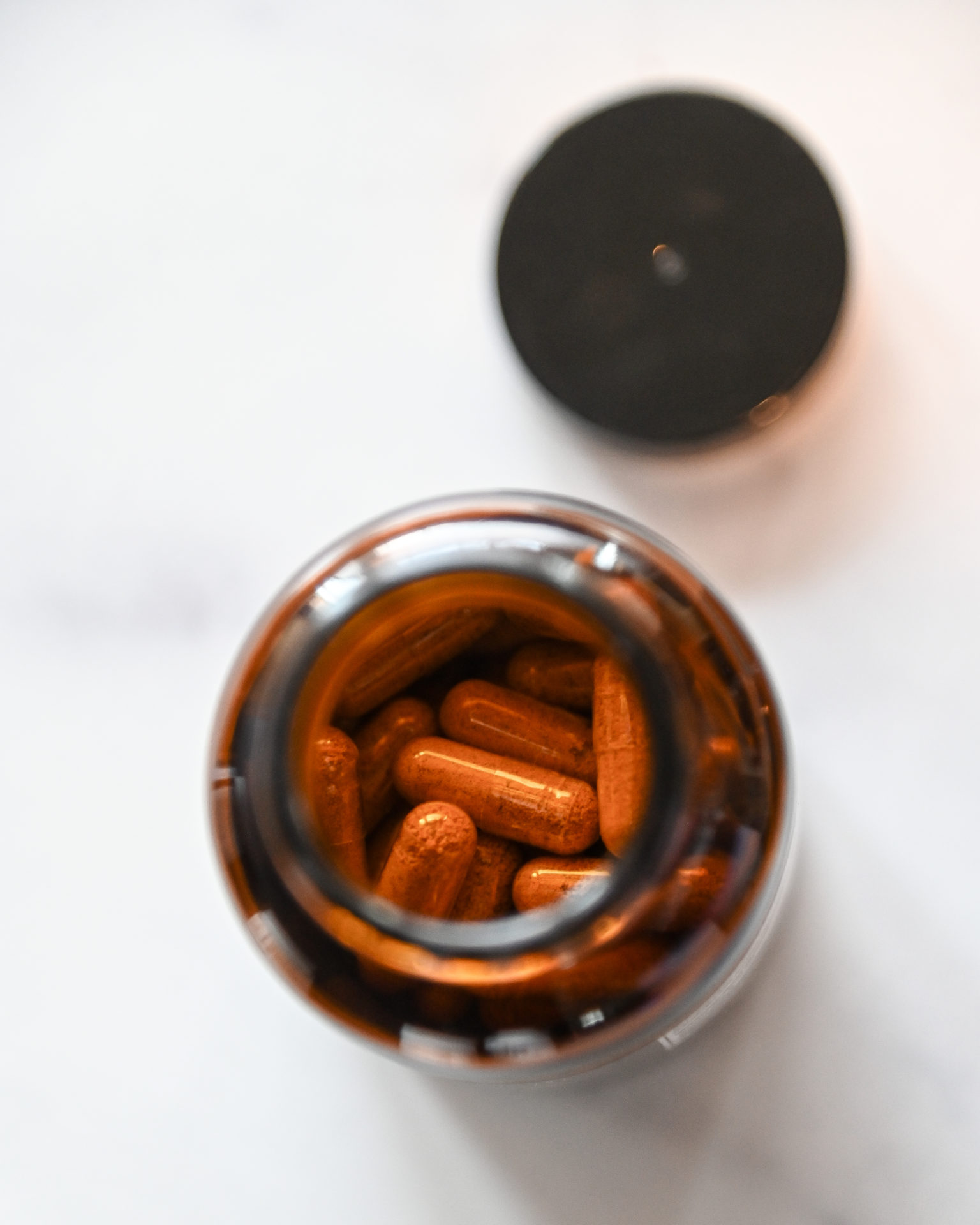 Looking into a jar of hemp capsules with turmeric.
