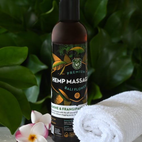 A bottle of hemp massage oil with a bali flower.