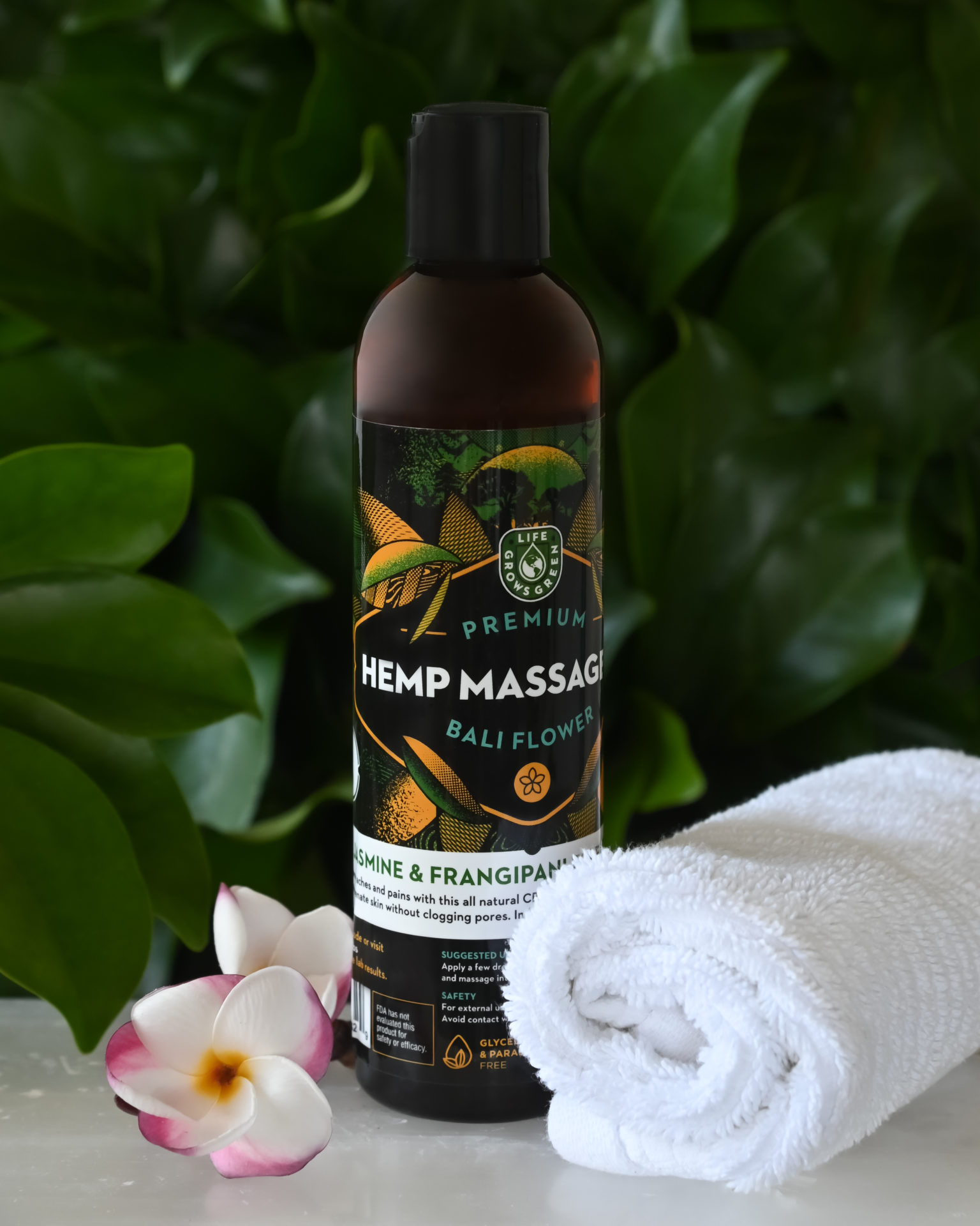 A bottle of hemp massage oil with a bali flower.